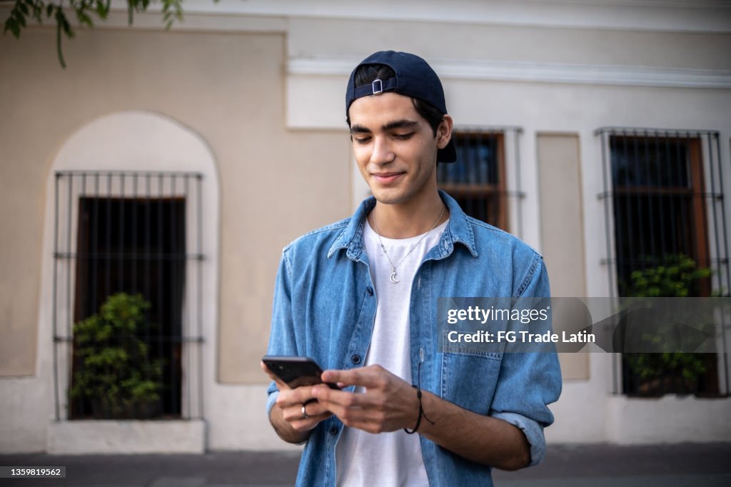 Teenager boy using the mobile phone outdoors
