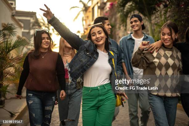teenager-freunde, die im freien spazieren gehen und tanzen - lateinamerikaner oder hispanic stock-fotos und bilder