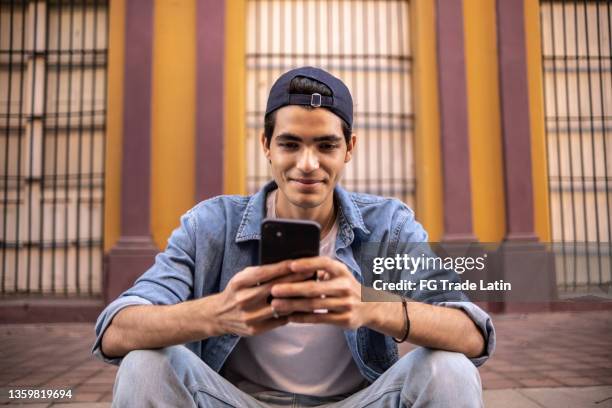 ragazzo adolescente che usa il telefono cellulare all'aperto - cultura latino americana foto e immagini stock