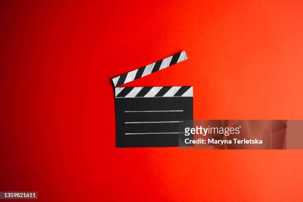 black and white clapperboard for shooting on a red background. universal abstract background in red. cinema minimalistic background. - film director foto e immagini stock