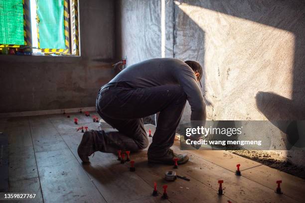 a bricklayer is laying tiles. - mörtel stock-fotos und bilder