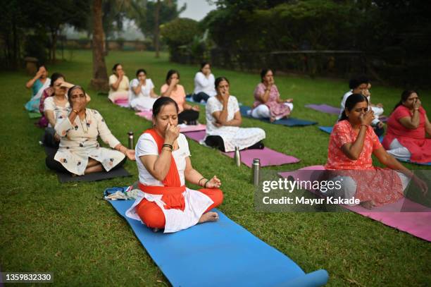 senior women doing yoga exercises in a park - yoga class stock pictures, royalty-free photos & images