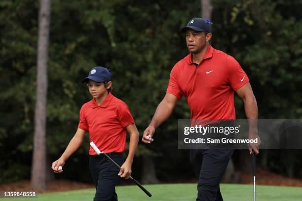 Tiger Woods and Charlie Woods walk from the first green during the final round of the PNC Championship at the Ritz Carlton Golf Club Grande Lakes on...