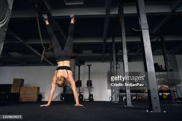 strong and flexible sportswoman, doing the handstand in the gym - handstand stock pictures, royalty-free photos & images