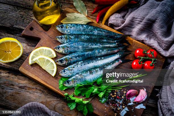 raw sardines on a cutting board. top view - omega 3 fish stock pictures, royalty-free photos & images