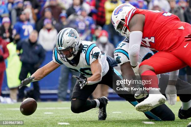 Chuba Hubbard of the Carolina Panthers fumbles the ball and is able to recover over the defense of Vernon Butler of the Buffalo Bills in the first...