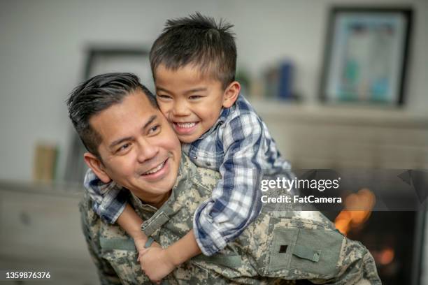 little boy piggy backing his military father - armed forces military family stock pictures, royalty-free photos & images