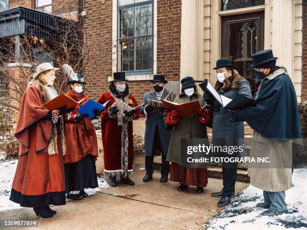 choir of carol singers performing on the street - carol stock pictures, royalty-free photos & images