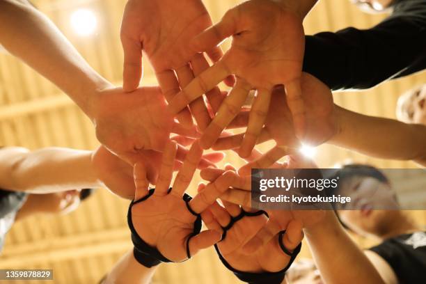 athletes pile their hands together in a circle - basketball womens college imagens e fotografias de stock