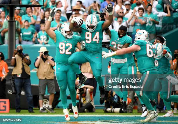 Christian Wilkins of the Miami Dolphins celebrates with teammates after scoring on a touchdown reception against the New York Jets in the fourth...