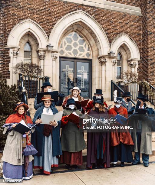 coro di cantanti di canto che si esibiscono davanti alla chiesa - christmas carols foto e immagini stock