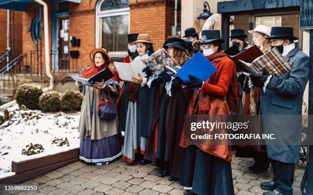 choir of carol singers performing on the street - carol singer stock pictures, royalty-free photos & images