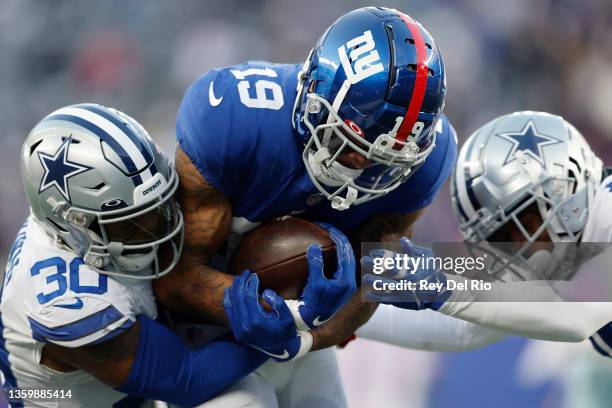 Kenny Golladay of the New York Giants catches the ball and is tackled by Anthony Brown of the Dallas Cowboys during the fourth quarter at MetLife...