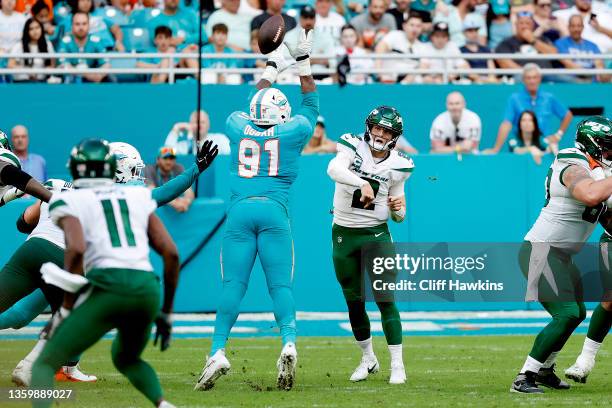 Emmanuel Ogbah of the Miami Dolphins blocks a pass attempt by Zach Wilson of the New York Jets in the second half at Hard Rock Stadium on December...