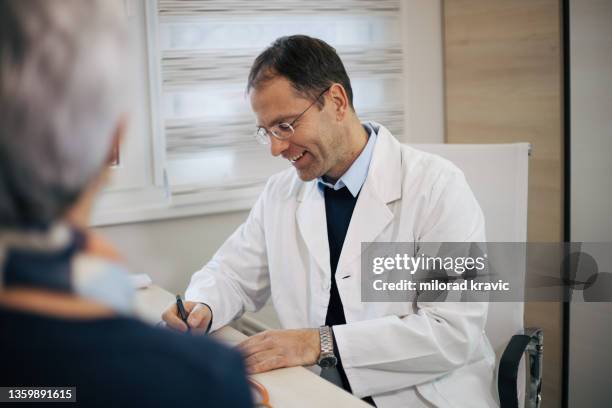 senior woman patient visit a doctor - patient history stock pictures, royalty-free photos & images