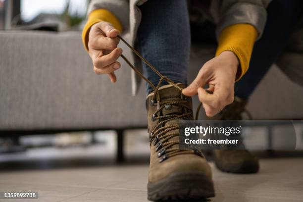 nahaufnahme der stiefel der frau beim binden des schnürsenkels - tie close up stock-fotos und bilder