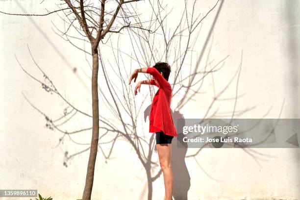 young woman dancing forming shadows on the wall - art from the shadows stockfoto's en -beelden