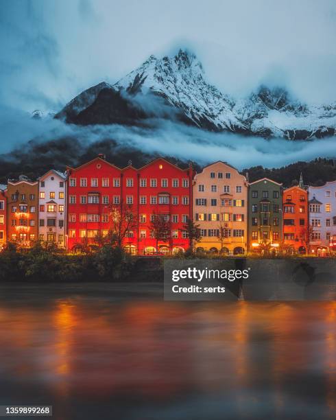 innsbruck stadtblick am wintertag - bunte häuser und schneebedeckte berge mit nebligem dunst im historischen stadtkern tirols im westen österreichs. - winter travel stock-fotos und bilder