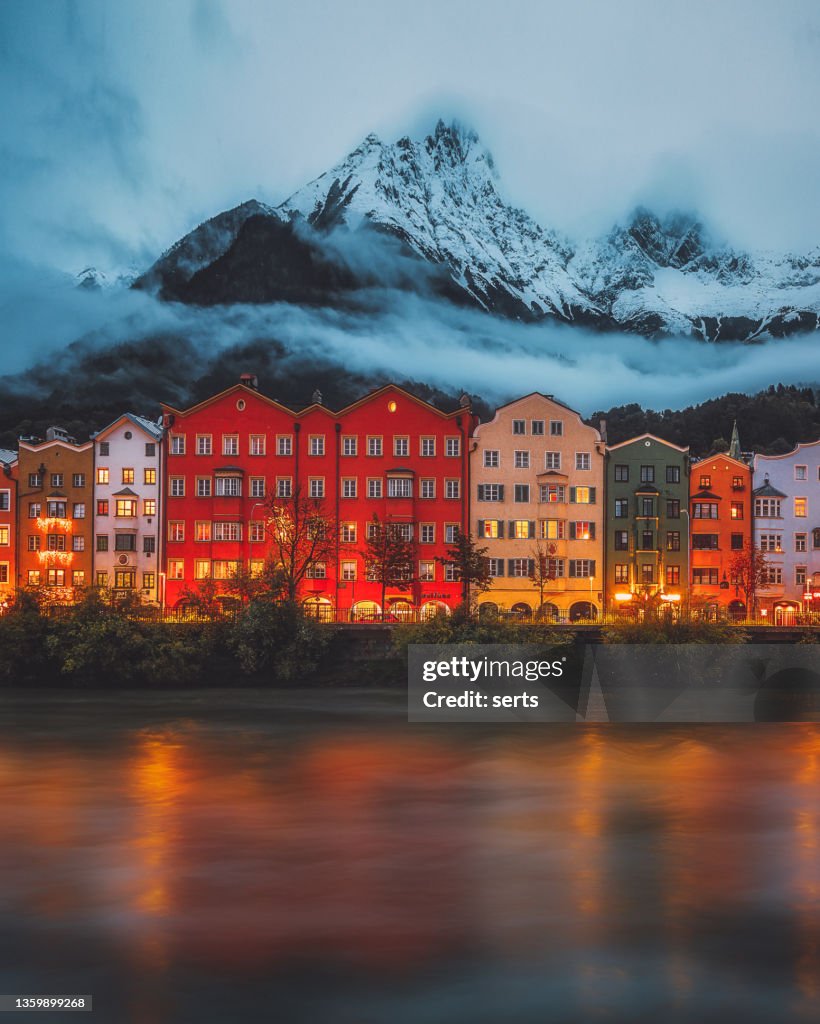 Innsbruck city view on winter day - Colourful houses and mountains covered by snow with misty haze in the historic city centre Tyrol in western Austria.