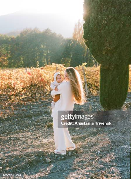 mom and her daughters walking in a field with vineyards and cypress. - italian cypress - fotografias e filmes do acervo