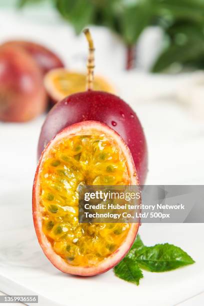 on the stone plate were cut red peel passion fruit - cut in half ストックフォトと画像