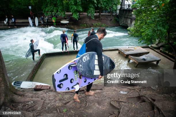 Local Munich River Surfer Alex Neumann prepares to start the day surfing at the Eisbach, Munich, Bavaria, Germany in 2019. The Eisbach is a 2...