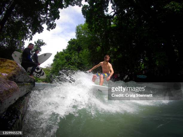 Surfing The Eisbach in Munich, Bavaria, Germany in 2019. The Eisbach is a 2 kilometer man made river in Munich and it is the hub of the land locked...