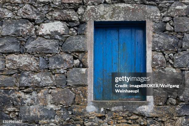 residential house with stone facade and blue closed window in rocha da relva, sao miguel island, azores, portugal - relva stock-fotos und bilder