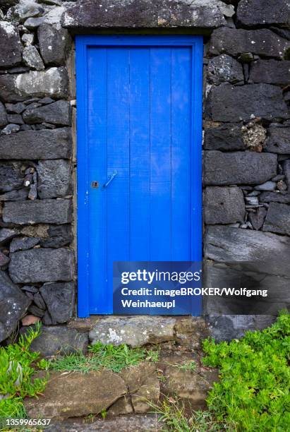 lava stone house facade with blue front door, rocha da relva, sao miguel, azores, portugal - relva stock-fotos und bilder