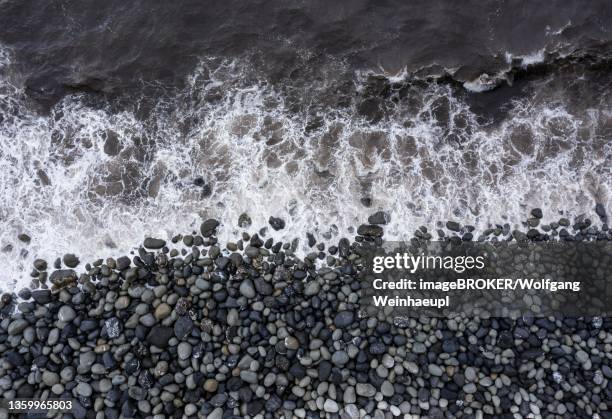 drone shot, surf with big round stones on the beach of rocha da relva, sao miguel island, azores, portugal - relva stock-fotos und bilder