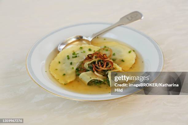 swabian cuisine, maultaschen in broth with stewed onion rings and chives, soup plate, spoon, germany - maultaschen stock pictures, royalty-free photos & images