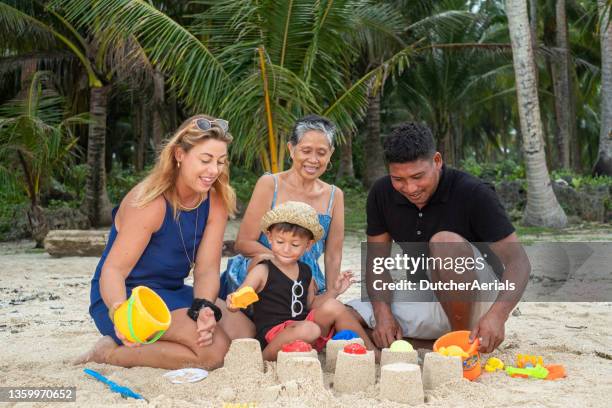 multi generation family playing on beach - philippines family stock pictures, royalty-free photos & images