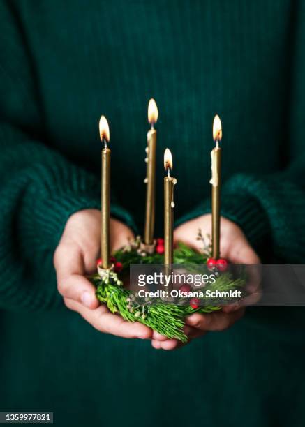 beautiful small christmas wreath with four burning gold candles in girls hand. - advent stock-fotos und bilder