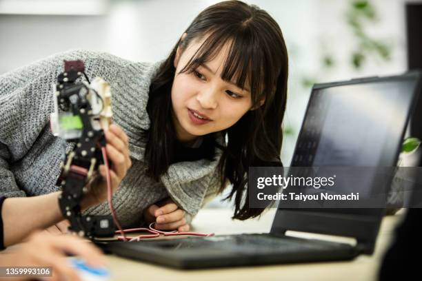 a female employee of a start-up company checks a prototype robot - プロトタイプ ストックフォトと画像