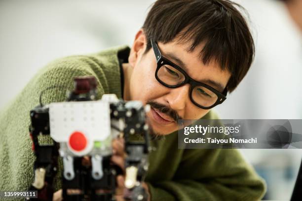 an engineer at a start-up company checks out a prototype robot - sustainable business stock pictures, royalty-free photos & images