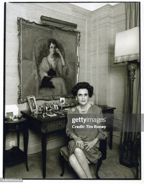 Margaret Campbell, Duchess of Argyll in an apartment at The Grosvenor House Hotel, London, circa 1990; she is sitting in front of a portrait of...
