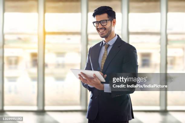 a corporate employee in formal business suit holding a digital tablet addressing a conference. - formal office stock pictures, royalty-free photos & images