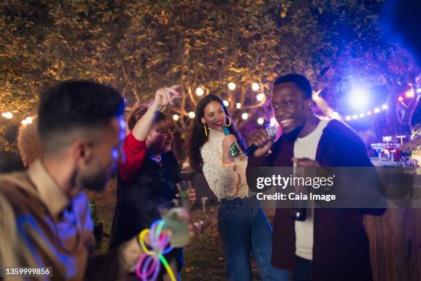 friends dancing and singing karaoke at garden party - garden night photos et images de collection