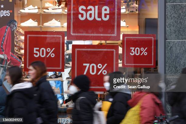 Shoppers walk past a store advertising sales on Schlossstrasse shopping street in Steglitz district during the fourth wave of the novel coronavirus...
