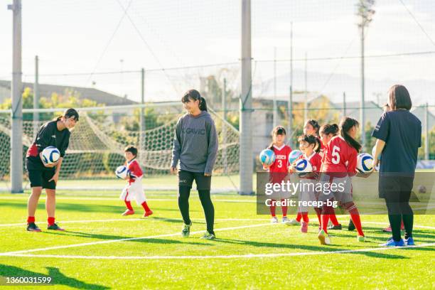 トレーニングを述べる前に、コーチのインストラクターに耳を傾ける女子子供サッカーまたはサッカーチームのメンバー - football team ストックフォトと画像