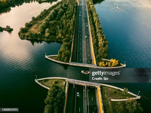 aquaduct veluwemeer in the veluwe lake with a boat sailing in the canal - netherlands bridge stockfoto's en -beelden
