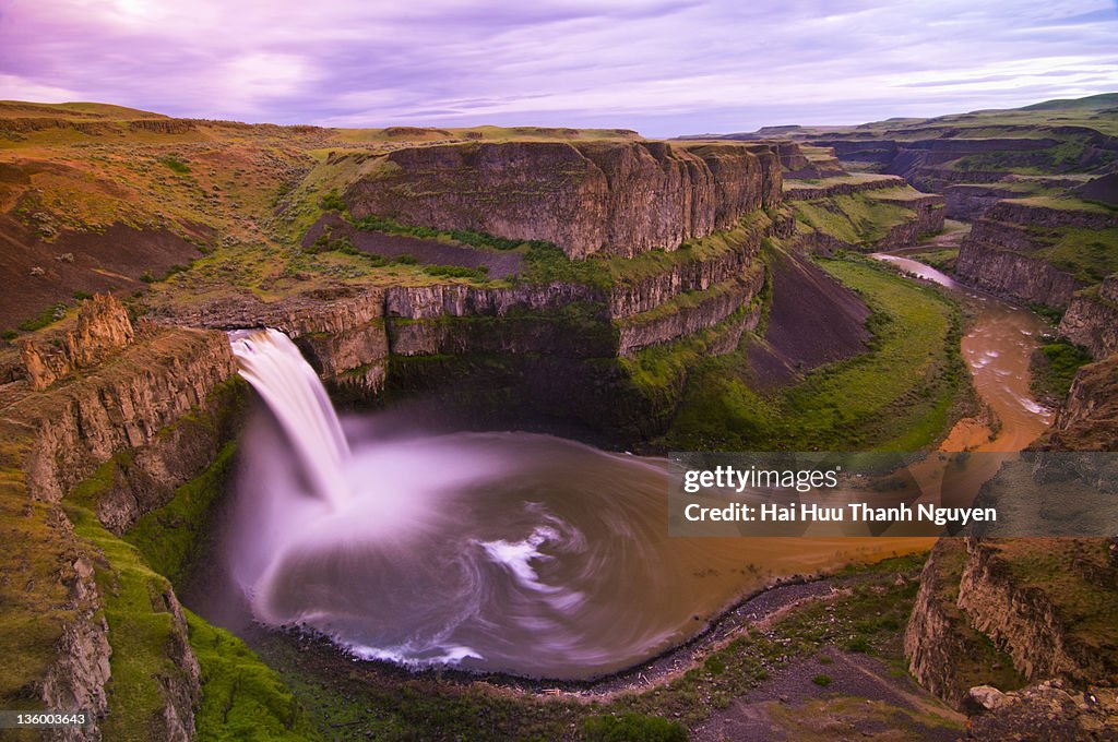 Rolling landscape with waterfall at dusk