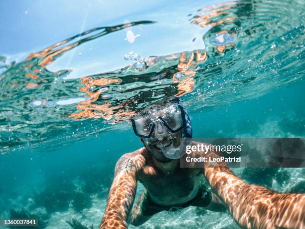 hombre snorkeling en vacaciones - snorkeling fotografías e imágenes de stock