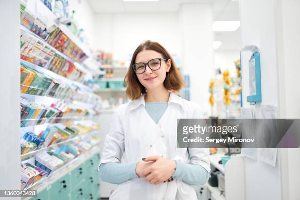 cheerful woman in modern pharmacy - pharmacist stock-fotos und bilder
