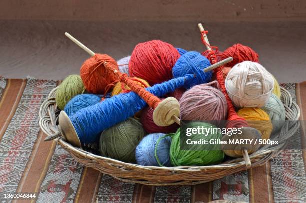 camelids from america,high angle view of multi colored wool balls in basket on table - stricknadel stock-fotos und bilder