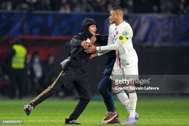 Kylian Mbappe of Paris SG reacts with a streaker during the French Cup game between Entente Feignes-Aulnoye and PSG on December 19, 2021 in...