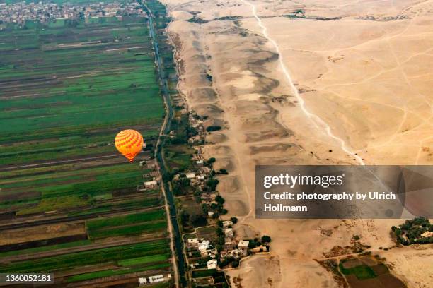 hot air balloon at sunrise over valley of kings, luxor, egypt - nile river stock-fotos und bilder