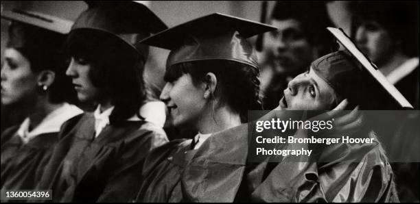 View of high school students, one of whom adjusts her cap, during their graduation ceremony, Glendale, California, 1982.