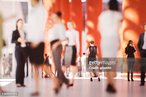 businesswomen standing in crowds of office workers - large conference event stock pictures, royalty-free photos & images