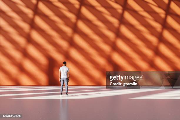 hombre casual de pie en el gran vestíbulo vacío de la oficina - arquitectura fotografías e imágenes de stock